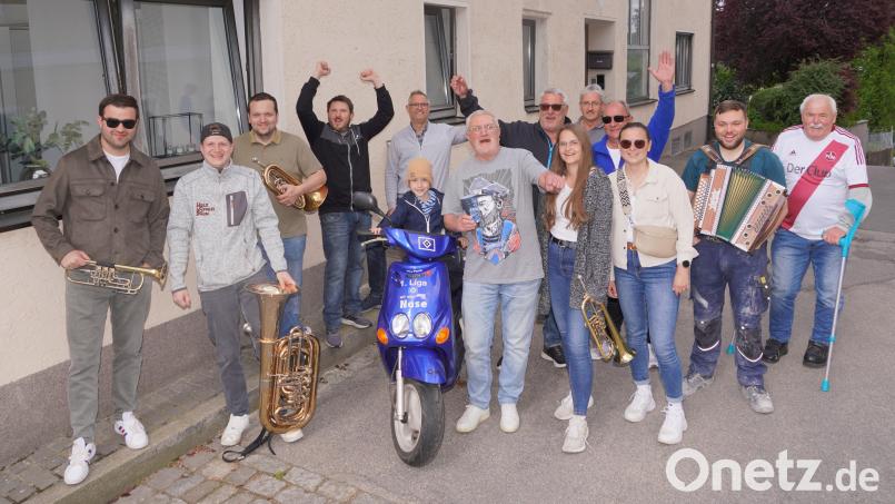 Freunde von Werner Wagner (rechts neben seinem Fan-Roller) laden zur spontanen HSV-Aufstiegfeier am Haus des HSV-Edelfans ein. Bild: fvo