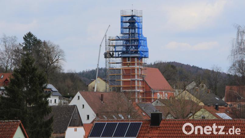 Umgeben von einer Schutzplane erneuern Fachkräfte die schadhaften Gebälkteile an der Turmspitze von St. Nikolaus in Etzelwang. Bild: ds