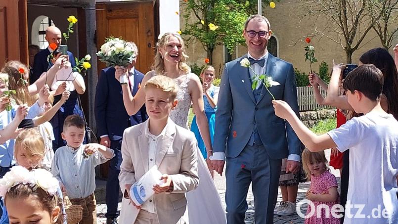 Nach der kirchlichen Trauung freuen sich Anna und Florian Zwicknagel über viele Gratulanten. Schüler der Braut überreichen Rosen. Bild: Susanne Hutzler