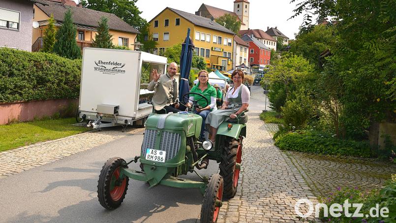 Der Oberpfälzer BBV-Präsident Ely Eibisch, hier zusammen mit Ortsbäuerin Brigitte Gnan (rechts), wird von einem Mitglied der Bulldogfreunde begrüßt und durch den Ort gefahren. Bild: fdl
