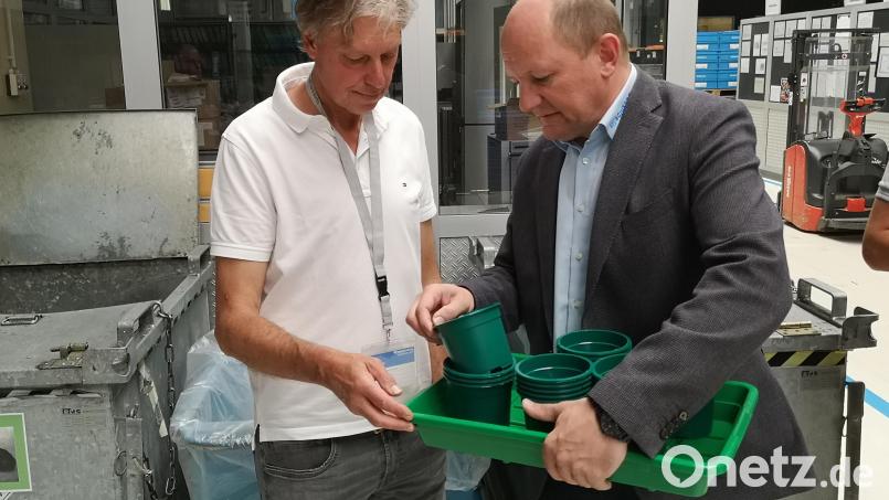 Gartenbau-Ingenieur Hans-Joachim Schinner (links) und Scherdel-Wiesauplast-Geschäftsführer Wolfgang Beer zeigen in einer Produktionshalle mehrere Exemplare des gemeinsam entwickelten biologisch abbaubaren Pflanztopfs. Bild: lnz