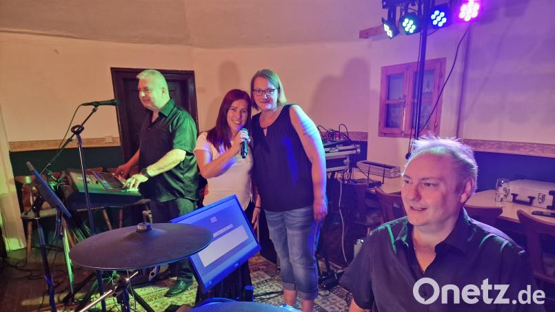 Jasmin Ludewig (Mitte) neben Sängerin Nadja Sommer, dahinter am Keyboard Georg Schachtel, dankt der Partyband „Perfect“ um Markus Roth (rechts am Schlagzeug) für das Benefizkonzert im Postkeller. Der Erlös von 1.400 Euro geht an ihre Krebstherapie. Bild: R. Kreuzer
