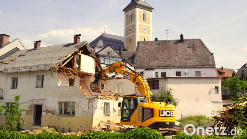 Die Greifzange des Baggers nimmt das alte Riedl-Haus ins Visier. Grün- und Gartenflächen entstehen dort. Bild: bkr