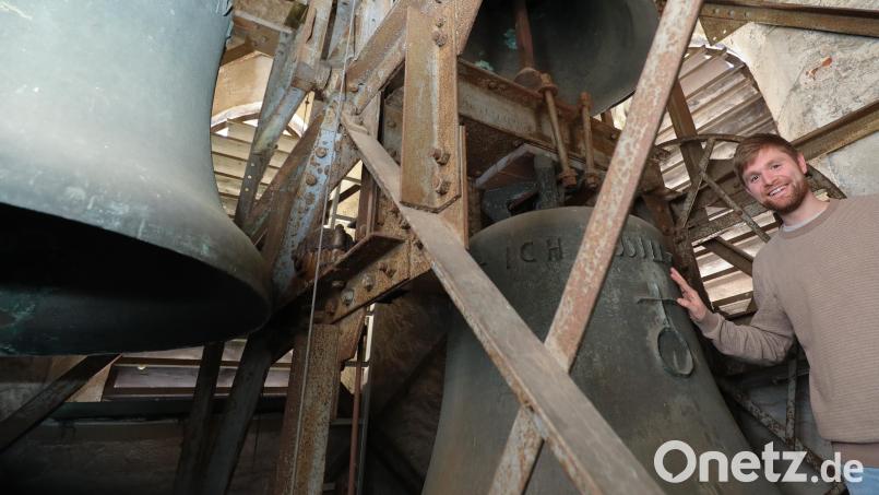 Daniel Götzfried steht im Kirchturm und hält seine Hand auf die über eine Tonne schwere Glocke, die bald ausgetauscht wird. Seit sechs Jahren ertönt nur noch das Stundengeläut, ansonsten Schweigen die Glocken aus Sicherheitsgründen. Bild: Wolfgang Steinbacher