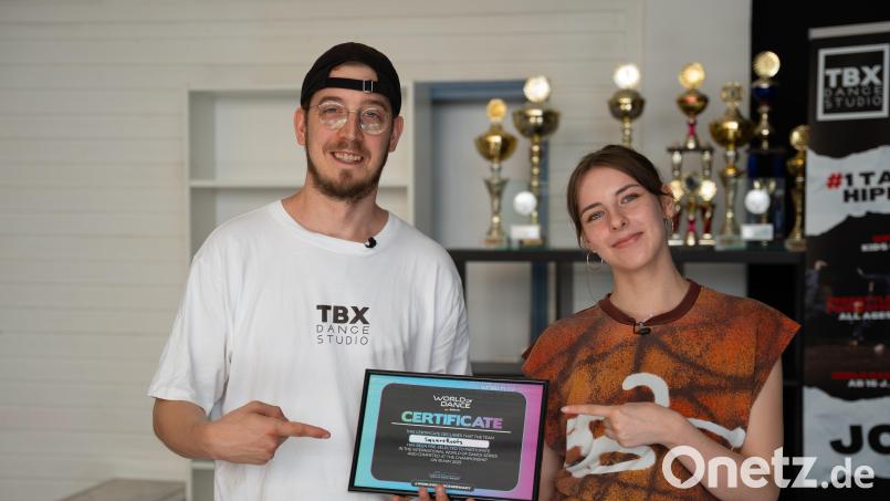 Christopher Orndorff (links) und Hannah Glasner (rechts) zeigen stolz ihr Teilnahmezertifikat von &quot;The World of Dance 2025&quot; Bild: Lisa Stauß