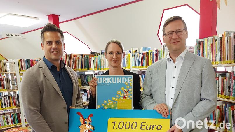 Bürgermeister Rudolf Teplitzky (links) und Heike Hagl von der Stadtbibliothek Oberviechtach freuen sich über den Preis, welchen Wolfgang Dumm vom Bayernwerk überreicht. Bild: Stadt Oberviechtach