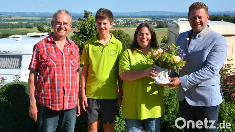Blumen gab es von Bürgermeister und Gewerbevereinsvorsitzenden Stefan Grillmeier (rechts) für die Auszeichnung zu Europas beliebtesten Campingplatz an Andrea Dolles, Sohn Yannick und Seniorchef Gerhard Lang. Jährlich verzeichnet die Anlage bis zu 30.000 Übernachtungen. Bild: jr
