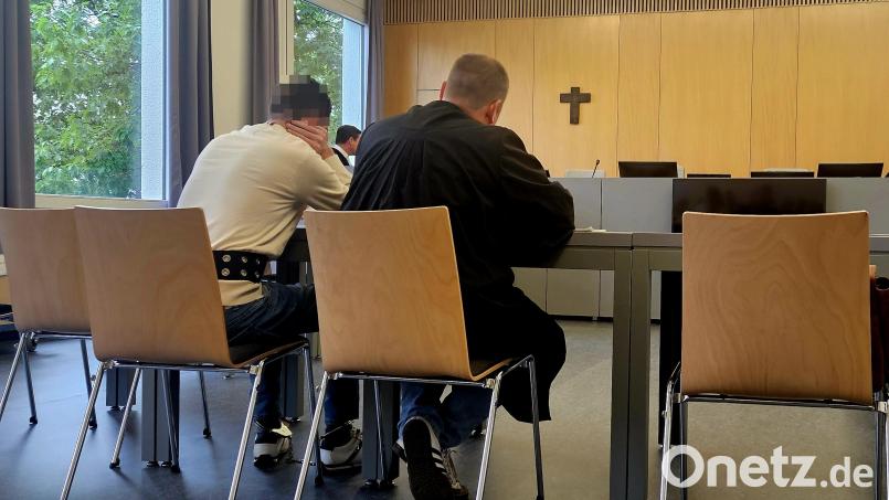Der angeklagte Immobilienmakler (links) trägt während des Prozesstages Bauchgurt und Fußfessel. Neben ihm sitzt sein Verteidiger Oliver Plate. Bild: blf