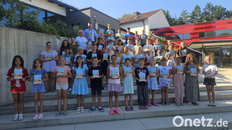 Stolz präsentieren die Schülerinnen und Schüler der Klassen 3a und 3b der Grundschule Vilseck das Kinderbuch „Villy‘s Vilseck – Entdecke deine Heimat“, das Autor Frederic Pröls überreicht hatte. Bild: Karl Heinz Grollmisch