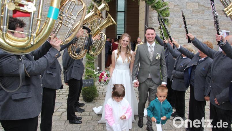 Freudestrahlend verlassen Anna-Maria und Christian Schmeller die Klosterkapelle in Johannisthal und werden von der Waldsassener Stadtkapelle im Ehrenspalier erwartet. Mit dabei die beiden Brautkinder Samuel und Luise. Bild: kro