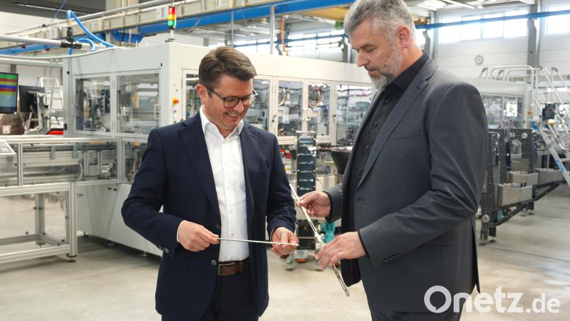 Die beiden Geschäftsführer von PIA Automation Amberg, Johannes Strasser (links) und André Vales begutachten Fensterbeschläge, die eine von der Amberger Firma konstruierte Anlage herstellt. Bild: jut