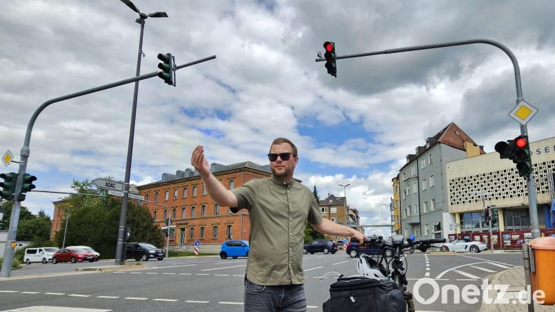 Christian Rockinger vom Tiefbauamt der Stadt zeigt: Wenn jetzt ein Auto von der Schillerstraße aus auf den Adolf-Kolping-Platz zufährt, wird an der Ampel das dort angebrachte einzelne, orangene Signal blinken und vor einem möglichen Konflikt zwischen Radler und rechtsabbiegenden Fahrzeugen warnen. Bild: Sonja Kaute