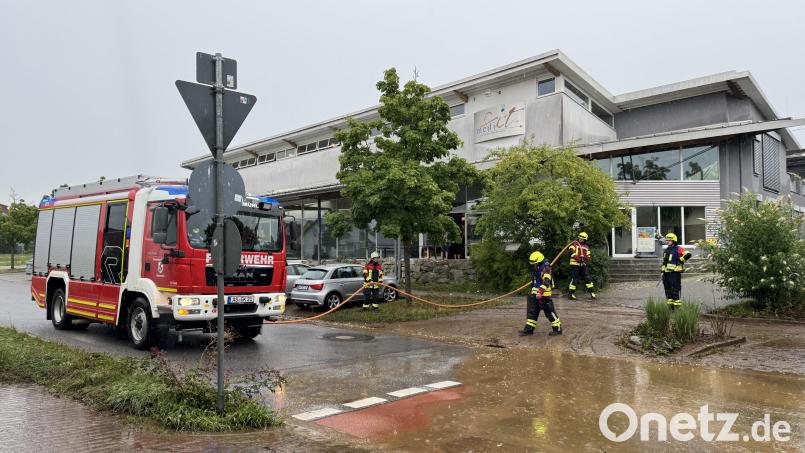 Nachdem ein Radlader den dicksten Dreck weggeschaufelt hatte, säuberte die Feuerwehr mithilfe von Schläuchen die verschlammte Sebastian-Kneipp-Straße beim Medifit in Kümmersbruck. Bild: Heike Unger