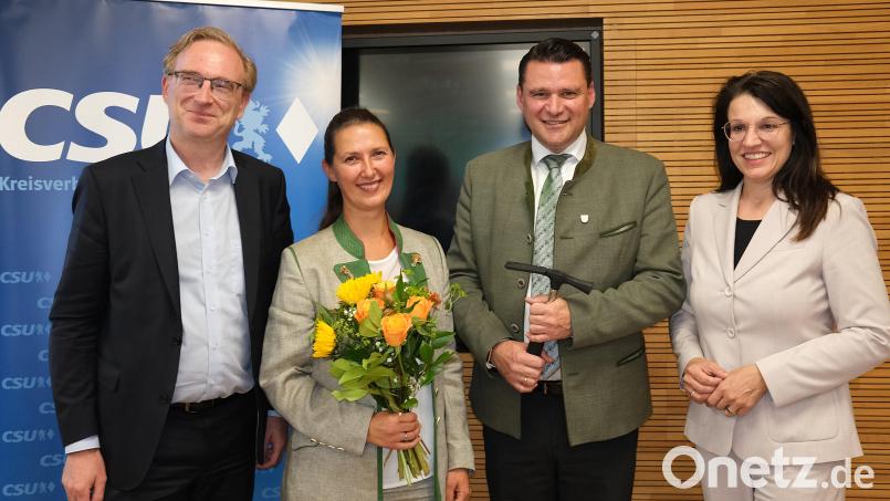 Blumen für Ehefrau Sina Just und symbolisch einen Hammer für Landrat Thomas Ebeling: CSU-Kreisvorsitzender Alexander Flierl (links) und seine Stellvertreterin Martina Englhardt-Kopf (rechts) gratulierten zum eindrucksvollen Delegiertenvotum. Bild: Hirsch