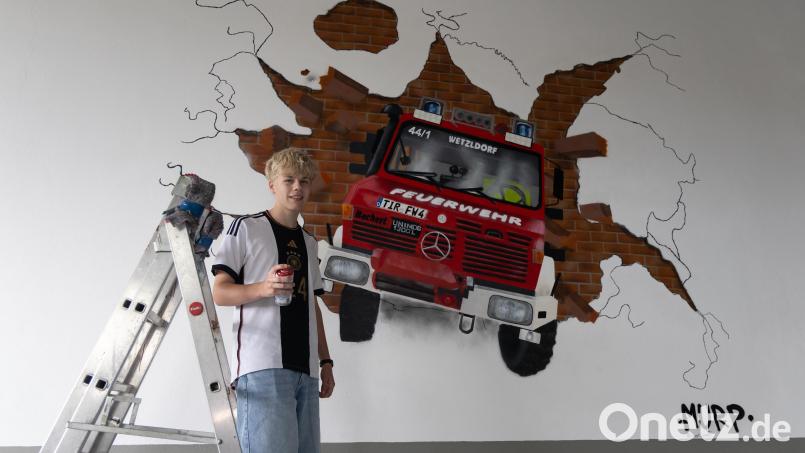 Matti (15) vor seinem beeindruckenden Kunstwerk: Der Unimog der Feuerwehr Wetzldorf, detailgetreu auf die Hallenwand gesprayt. Bild: Roland Wellenhoefer