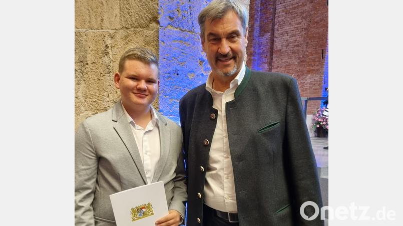 Bayerns Ministerpräsident Markus Söder gratuliert dem 15-jährigen Simon Hoschek zu seinem Abschluss an der Mittelschule Waldsassen. Bild: Andreas Hoschek/exb