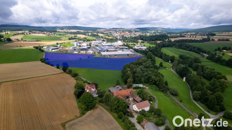 Um rund sechs Hektar (blaue Fläche) soll das Gewerbegebiet nach Westen erweitert werden. Zwischen dem Inglashof (im Vordergrund) und dem bestehenden Gewerbegebiet liegt in der geplanten Erweiterungsfläche ein Grundstück mit verbrieftem Wasserrecht – zentraler Streitpunkt in der aktuellen Diskussion. Bild: rw