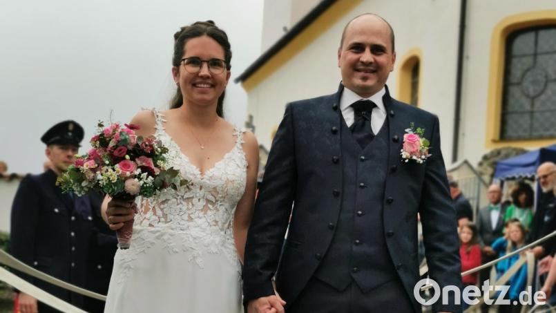 Magdalena und Manuel Müllner beim Durchschreiten des Spaliers vor der Kirche. Bild: hzi