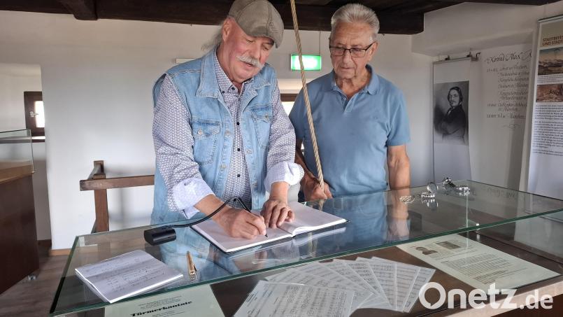 Bevor es an die Arbeit geht, legen die beiden Glöckner einen Tageseintrag im Gästebuch an. Bild: jua