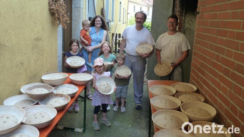 Das Brot steht zum „Einschießen“ durch die zwei Bäcker Herbert Seer und Julian Brucker bereit. Die Kinder durften gerne mithelfen und konnten hautnah miterleben, wie das Brot in den Backofen geschoben wurde. Bild: Robert Birkner