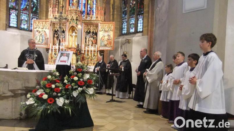 Der Altarraum in der Nabburger Stadtpfarrkirche St.Johannes mit Stadtpfarrer Hannes Lorenz (links) sowie dem Bildnis mit Blumen des verstorbenen Missionsbischofs Fritz Lobinger davor. Bild: Michael Götz