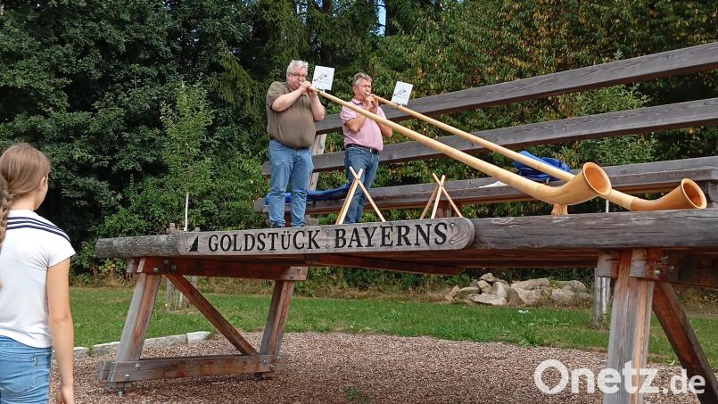 Wolfgang Rützel (links) und sein Musikkollege von den Lauertaler Alphornbläsern (Unterfranken) packen ihre großen Instrumente auf der XXL-Bank bei Oberviechtach für ein spontanes Ständchen aus. Bild: Maria Hagl