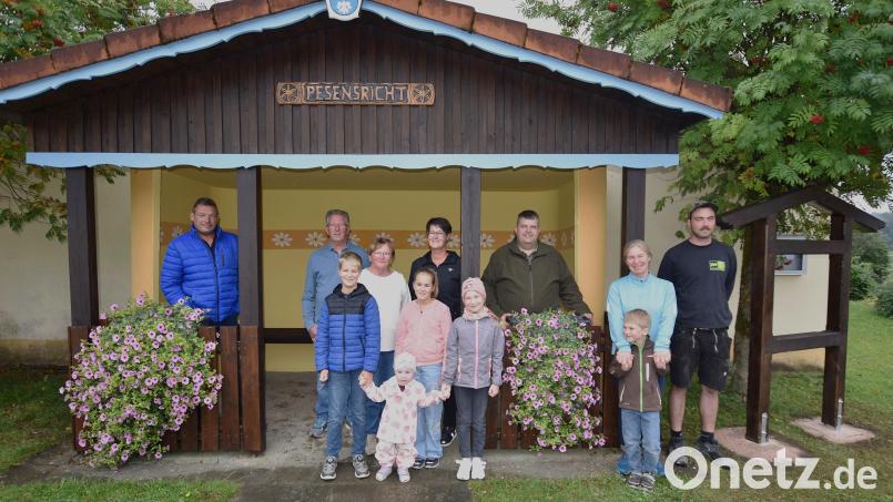 Kinder und Helfer aus Pesensricht stehen vor dem renovierten Buswartehäuschen. Mit dabei Grundstücksbesitzer Gerhard Meyer (von links) und die Initiatoren Gerd und Monika Meyer. Daneben die Helfer Nikki Übler mit Bürgermeister Dieter Dehling, Andrea Prosch und Michael Fleghel. Bild: no