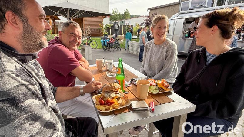 Ungezwungen zusammensitzen, Burger und Currywurst genießen: Das Alleinstellungsmerkmal von Rötzers Biergarten ist der silberne US-Streetliner im Hintergrund, der zum Burgergrill umgebaut wurde und US-Flair verströmt. Bild: Petra Hartl