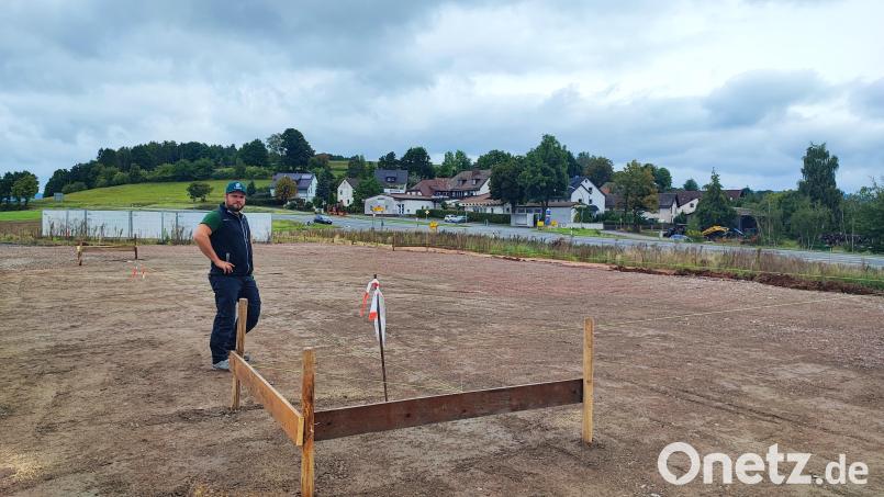 Schnüre markieren den Platz für das künftige Verwaltungsgebäude von Matthias Langs Garten- und Landschaftsbaufirma. Anfang Oktober soll die Bodenplatte gegossen werden. Im Hintergrund sind die Staatsstraße 2665 und die Ortschaft Löschwitz zu sehen. Bild: luk