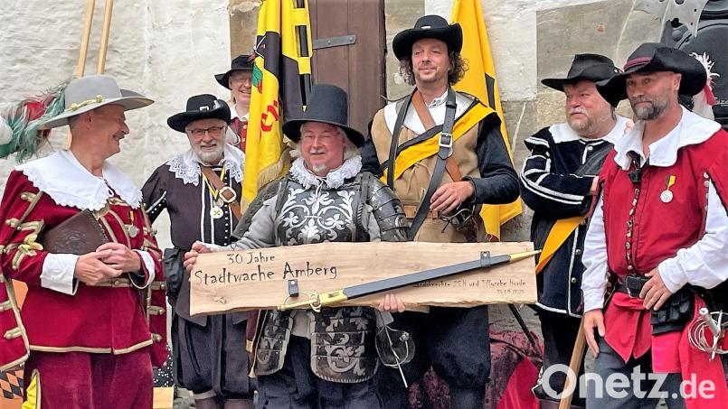 Neben vielen guten Wünschen zum 30-jährigen Bestehen brachten die Gäste aus Altdorf, Vertreter der Landsknechtsgruppe Zeh und der Tillyschen Horde, auch ein Brett mit einem darauf befestigten Schwert mit. Bild: Susanne Schwab