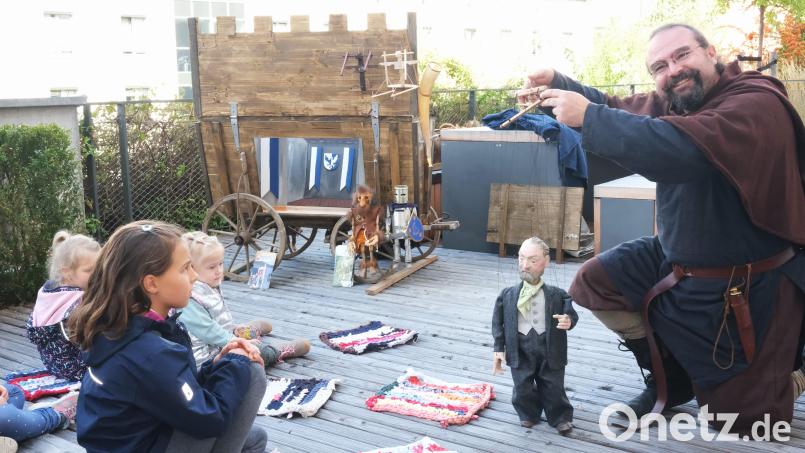 Mit der Marionette des Komponisten Konrad Max Kunz begrüßte Florian Waldherr (rechts) die Kinder auf der Terrasse des Tourismusbüros und stimmte mit ihnen ein Lied an. Bild: Hirsch