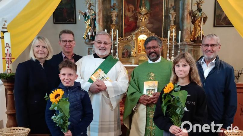 Mit Blumen und den Büchern begrüßten Pfarrgemeinderatssprecher Georg Hammer (Zweiter von links), Ruth Neumann (links), Kirchenpfleger Alfons Stangl (rechts) und Kinder vom Kreis junger Familien (vorne) den neuen Pfarrer Pater Jo (Zweiter von rechts) und Diakon Uli Wabra (Dritter von rechts) in der Pfarrkirche St. Ulrich in Michldorf. Bild: grm