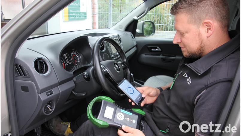 Dekra-Prüfingenieur Timo Hartwich checkt das Fahrzeug mit einem speziellen Testgerät und einem Handy. auf mögliche Fehler. Bild: kro