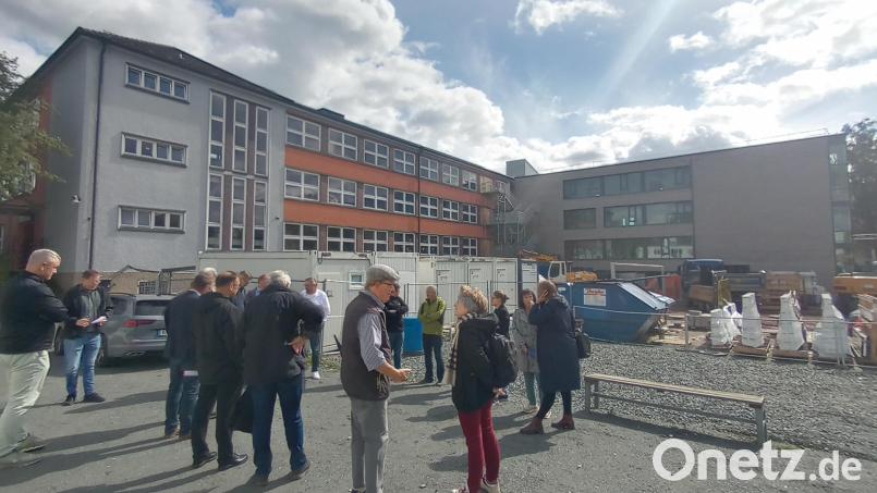 Der neue Klassentrakt (rechts) der Pestalozzi-Mittelschule in Weiden steht. Ziehen dort die Schüler ein, dann kann der Altbau (links) saniert werden. Der Bauausschuss macht sich ein Bild vor Ort. Bild: Hladik