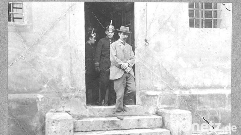 Der Kindsmörder, wie er, begleitet von Polizisten, aus der Amberger Fronfeste herauskommt. Die Stufen mit den beiden Steinen links und rechts sind heute noch da. Jetzt ist hier der Eingang zum Hotel Fronfeste. Archivbild: Tagebuch des Scharfrichters Franz Xaver Reichhart/Staatsarchiv München