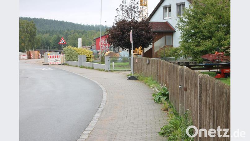 Schadhaft und in der Gestaltung nicht mehr zeitgemäß ist nach Auffassung der Gemeindeverantwortlichen der betongepflasterte Gehweg längs der Parksteiner Straße. Eine Erneuerung des Pflasters soll in die Städtebauförderung für die Arbeiten rund um das Gemeindezentrum (Hintergrund) einbezogen werden. Bild: Bernhard Piegsa