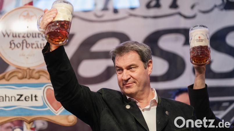 Der bayerische Ministerpräsident Markus Söder (CSU) hält auf der Bühne im Festzelt des Würzburger Frühlingsvolksfestes eine Maß Bier in der Hand. Bild: Nicolas Armer / dpa