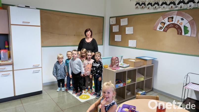 Damit die Kinder im Ausweichquartier des Kindergartens im Erdgeschoss der Grundschule im Ernstfall die Fluchttreppe an der Außenwand sicher erreichen können, erfolgt demnächst ein Durchbruch der Wand auf der rechten Seite. Kindergartenleiterin Nicole Lippert und einige Kinder warten bereits gespannt auf die bevorstehende Aktion. Bild: bsc