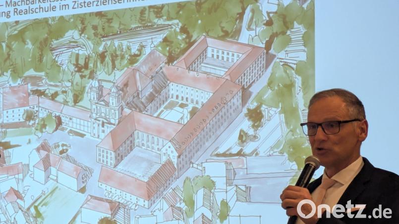 Bürgermeister Bernd Sommer während seines Vortrags in der jüngsten Bürgerversammlung. Auf der Leinwand zu sehen ist eine Skizze mit einer Ansicht des Klosters, an dem der Anbau (oberer Bildrand) für die erweiterte Realschule bereits verwirklicht ist. Bild: pz