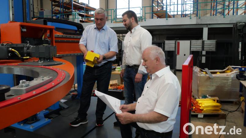 Rüdiger Kohls, Florian Meierhöfer und Alfons Meierhöfer (von links) an der Bandagiermaschine, die die einzelnen Säulen des stehenden Trafokerns mit einem höheren Glasfaserband umwickelt, um eine höhere Effizienz zu erzielen. Bild: Julia Benkhardt [jbe]