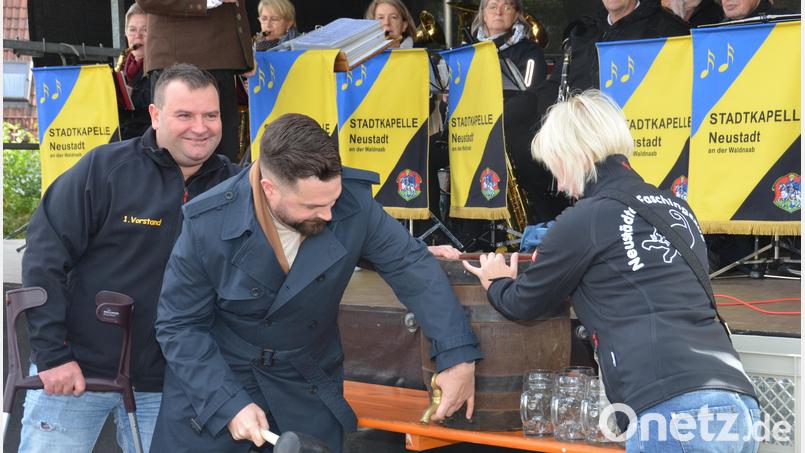 Bürgermeister Sebastian Giering zapft gekonnt ein Fass Bier an, um den Erntedankmarkt offiziell zu eröffnen. Faschingsvereinsvorsitzender Markus Trescher (links) schaut ihm dabei über die Schulter. Bild: dob