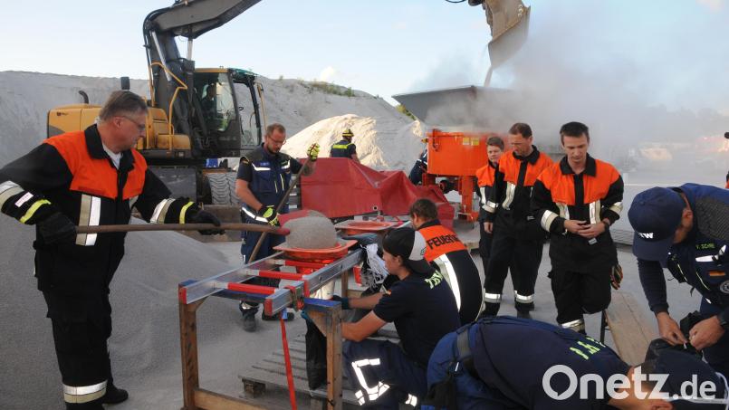 Übung für den Ernstfall: Vorne werden die Sandsäcke nach herkömmlicher Methode per Schaufel und Trichter gefüllt, hinten schüttet der Bagger Nachschub in die Sandsackmaschine. Bild: ge