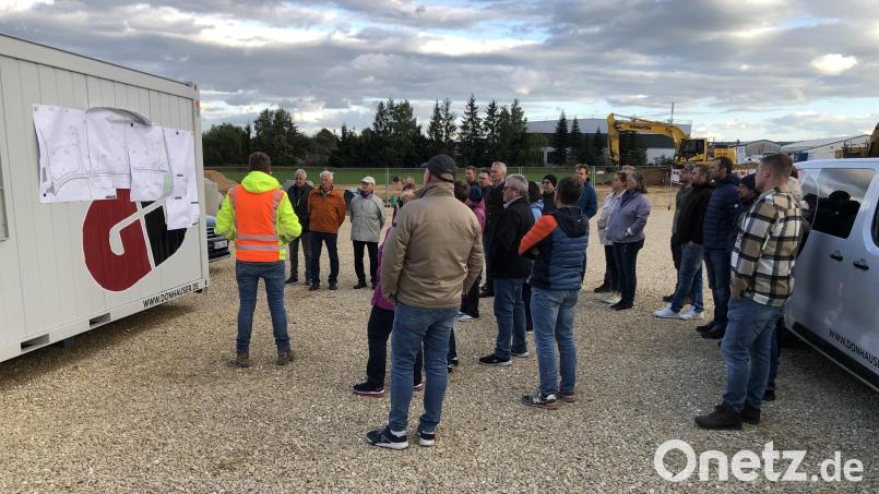 Anhand der Pläne und bei einem Rundgang durch das Gelände erläuterte Bauleiter Michael Zach (gelbrote Jacke) den Stand der Erschließung des neuen Gewerbegebiets am Neuhauser Steig in Vilseck. Bild: Christian Trummer