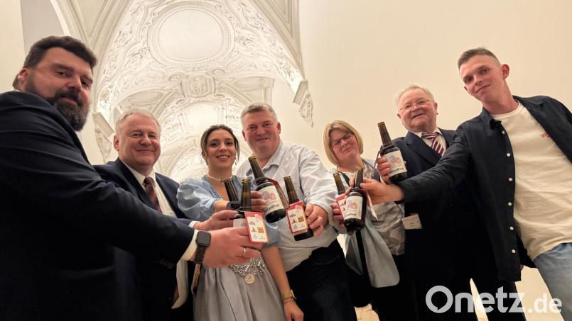 Mit dem Jubiläumsbier stießen die Oberpfälzer an: Bürgermeister Stefan Frank, Landrat Richard Reisinger, die bayerische Bierkönigin Anna Winkler, Bräu Armin und Frau Elke, Altbürgermeister Gerd Geismann und Fuchsbeck-Brauer David Grundler (von links). Bild: Landratsamt Amberg-Sulzbach/exb