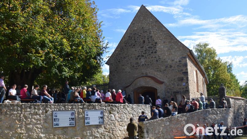 Pulsierendes Leben am Dorfplatz in Lutzmannstein. Viele der Teilnehmer des Heimattreffens in Lutzmannstein haben keinen Platz mehr in der ehemaligen Pfarrkirche bekommen. Sie scharten sich um die Friedhofsmauer und den Treppenaufgang zur Dorfkirche St. Maria und Sankt Luzia. Bild: bö