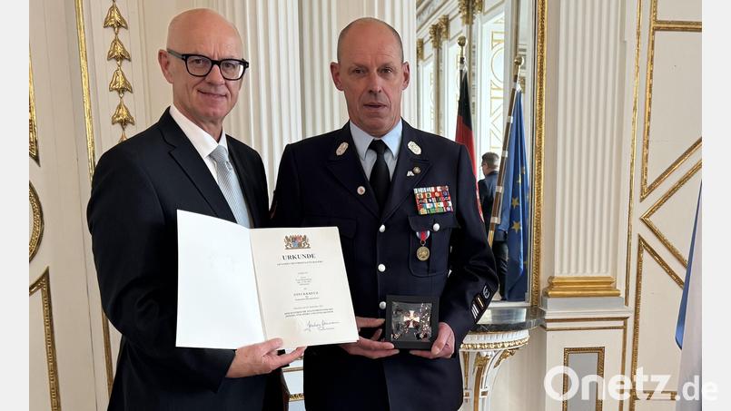 Ehrenkommandant Franz Bauernfeind (rechts) erhielt von Regierungspräsident Walter Jonas das Steckkreuz für besondere Verdienste um das Feuerwehrwesen. Bild: Regierung der Oberpfalz/Manfred Schmied/exb