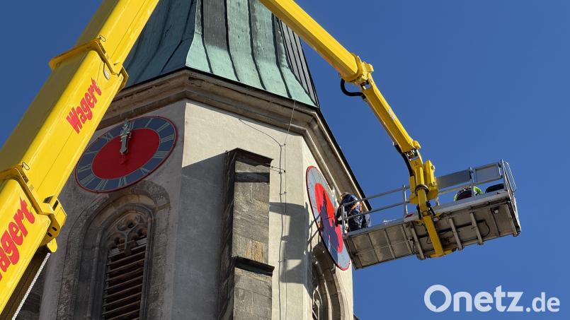 Spezialisten der Firma Bayreuther Turmuhren haben die restaurierten Zifferblätter und Zeiger wieder an den Turm der Kemnather Stadtpfarrkirche Mariä Himmelfahrt montiert. Ein Kran hievte die Arbeiter und die Einzelteile in der Hebebühne circa 40 Meter in die Höhe. Bild: Gabi Schönberger