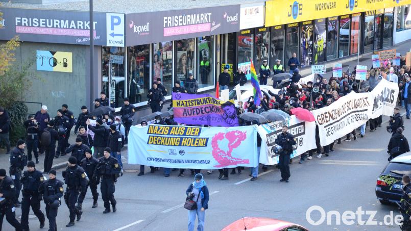 Sichtgeschützt von Transparenten marschieren die Demonstranten durch die Stadt. Bild: uz