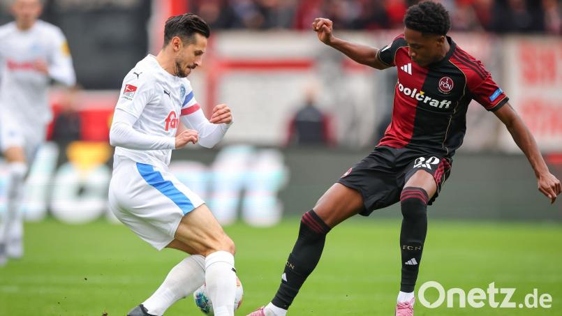 Kiel-Kapitän Steven Skrzybski (links) und Pape Demba Diop von Nürnberg kämpfen um den Ball. Bild: Daniel Karmann/dpa