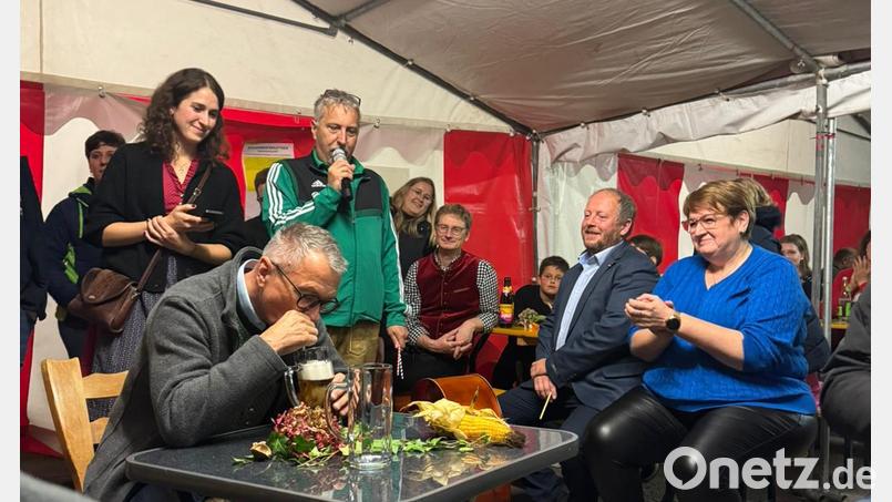 2. Bürgermeister Richard Brunner wird beim "Bürgermeisterauftrieb" beim Entleeren seiner Halben mit dem Strohhalm angefeuert. Bild: Becher Robert